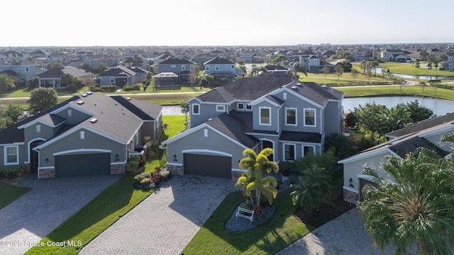 drone / aerial view featuring a residential view and a water view