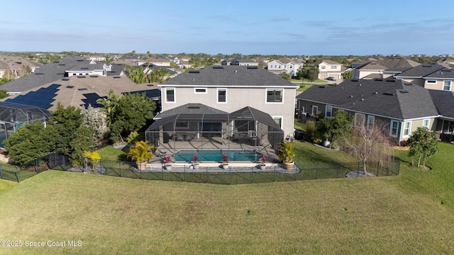 back of house with glass enclosure, a fenced backyard, and a yard