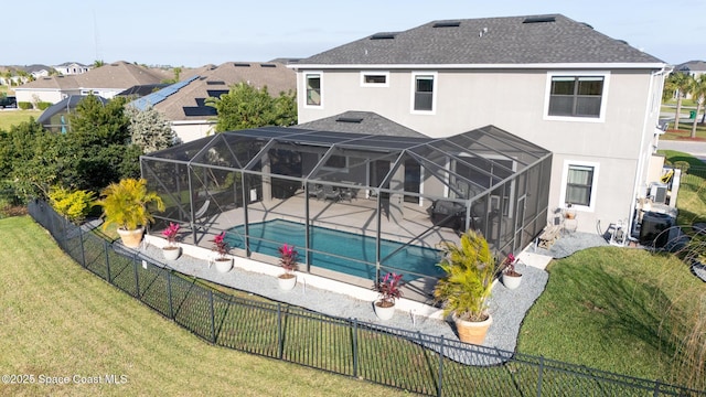 back of house featuring a fenced in pool, a yard, stucco siding, a lanai, and a fenced backyard