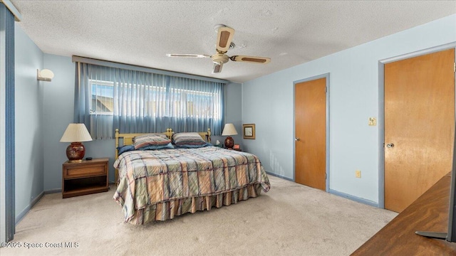 bedroom with light carpet, a textured ceiling, and baseboards