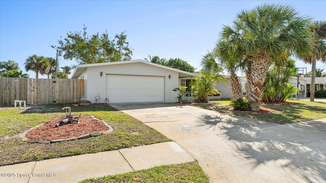 view of front of property featuring driveway, a front lawn, an attached garage, and fence