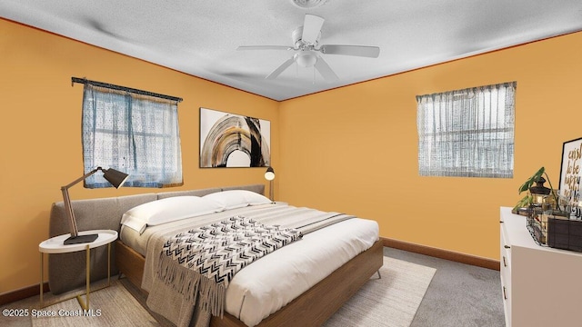 bedroom featuring a ceiling fan, light colored carpet, a textured ceiling, and baseboards