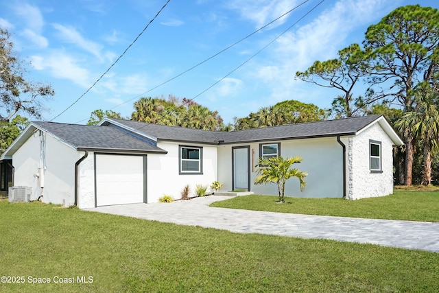 ranch-style house featuring a front yard, cooling unit, and a garage