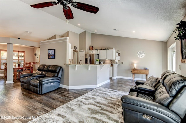 living room with lofted ceiling, sink, ceiling fan, a textured ceiling, and dark wood-type flooring