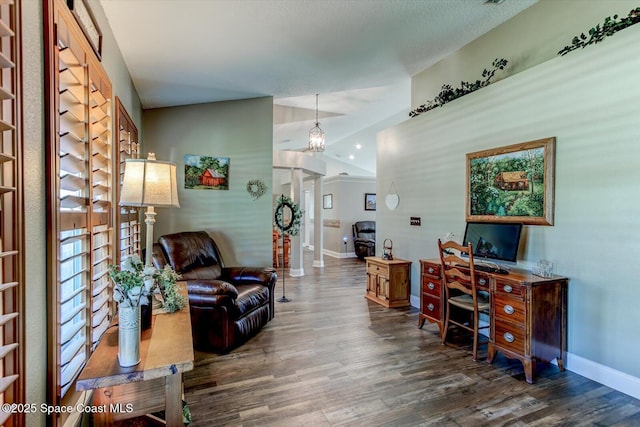 home office with a textured ceiling, ornate columns, and dark hardwood / wood-style flooring