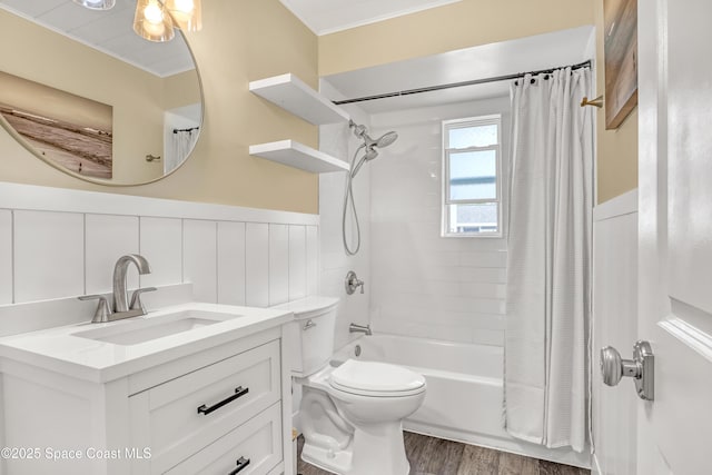 full bathroom featuring toilet, a wainscoted wall, wood finished floors, shower / bath combination with curtain, and vanity