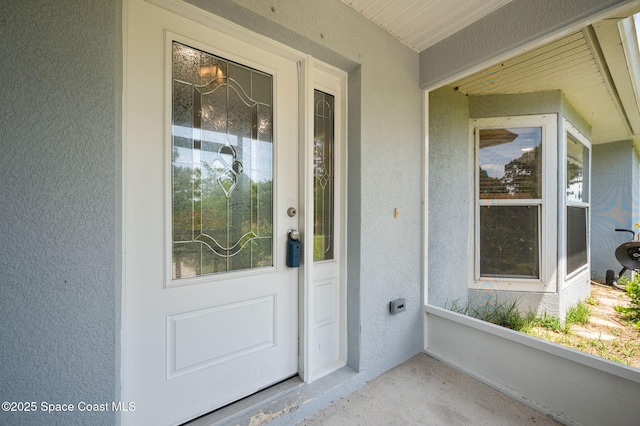doorway to property featuring stucco siding