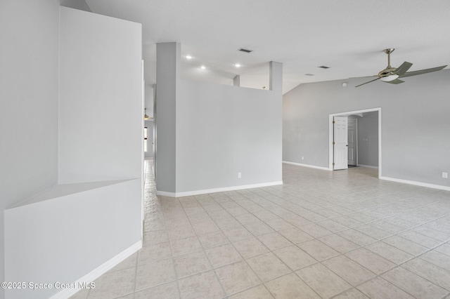 empty room with tile patterned flooring, vaulted ceiling, visible vents, a ceiling fan, and baseboards