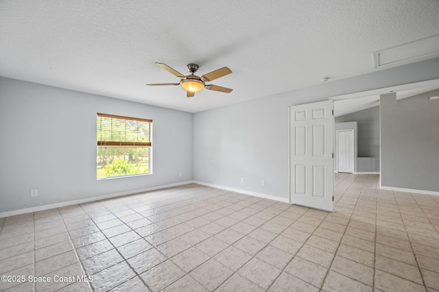 empty room featuring a textured ceiling, a ceiling fan, baseboards, and light tile patterned floors