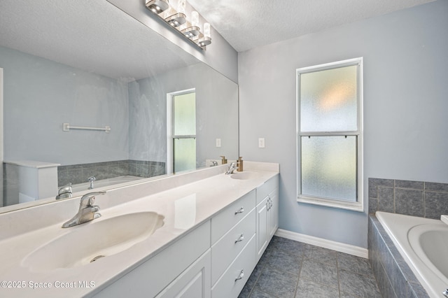 full bathroom featuring plenty of natural light, a textured ceiling, and a sink