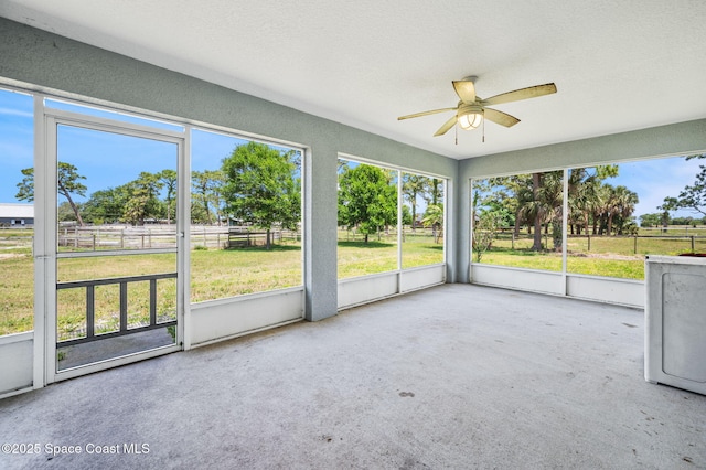 unfurnished sunroom featuring a ceiling fan