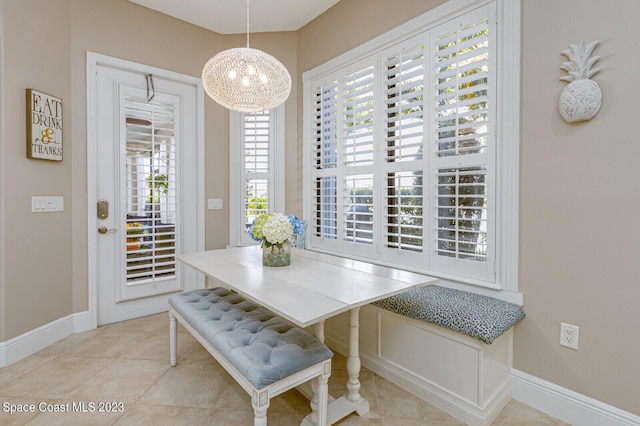 tiled dining room featuring a chandelier