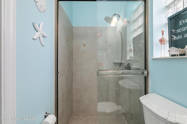 bathroom with an enclosed shower and toilet