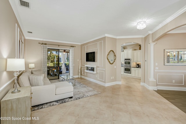 living room featuring light tile patterned floors, ornamental molding, and decorative columns