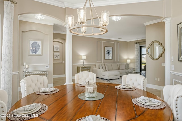 dining room with an inviting chandelier, ornamental molding, and decorative columns