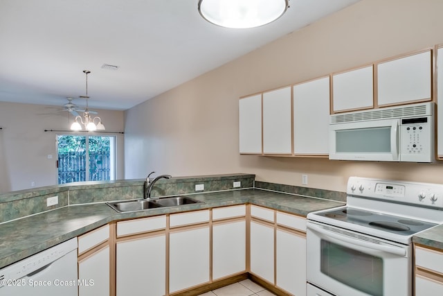 kitchen with sink, white appliances, a notable chandelier, white cabinets, and kitchen peninsula