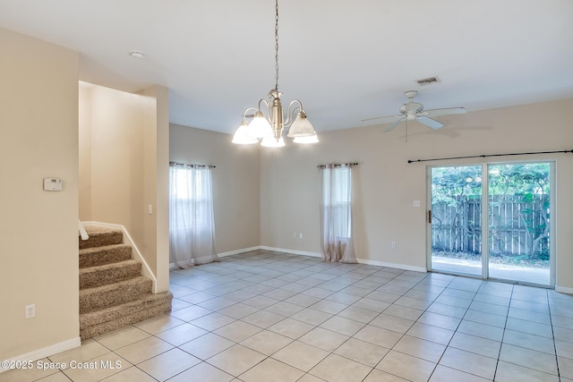 tiled spare room featuring ceiling fan with notable chandelier