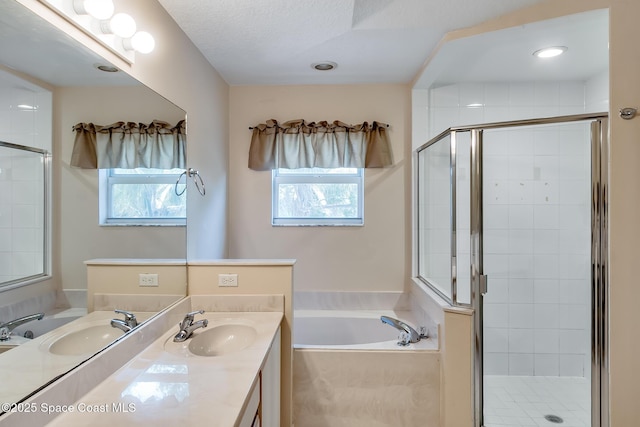 bathroom with vanity and shower with separate bathtub