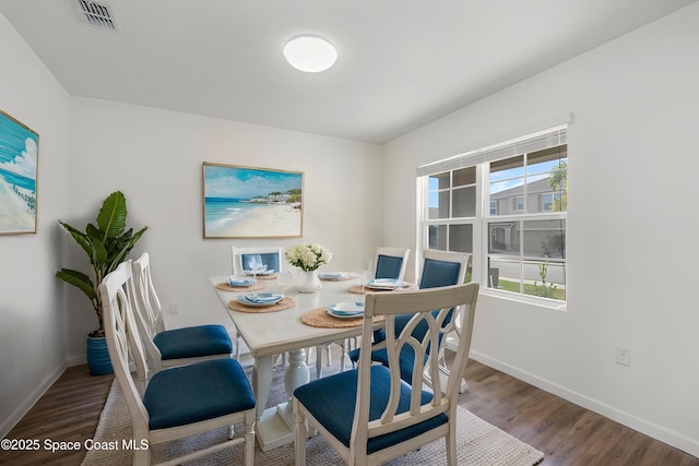 dining space featuring baseboards, visible vents, wood finished floors, and a wealth of natural light