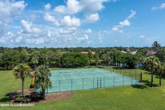 view of tennis court featuring fence and a yard