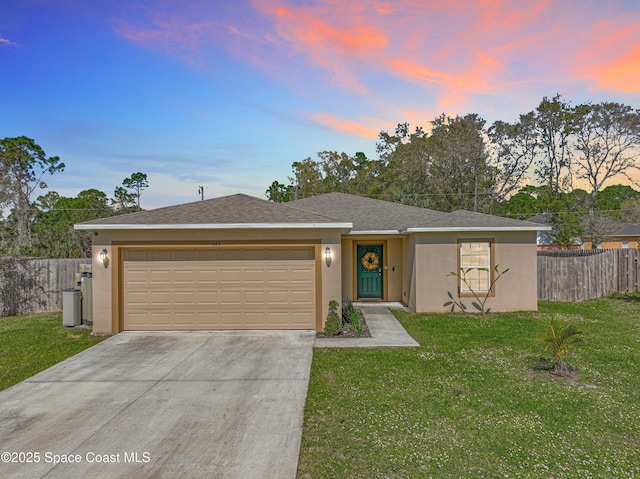 ranch-style house with driveway, a lawn, fence, and stucco siding