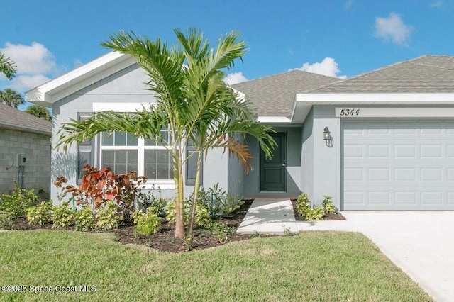 single story home with a garage and a front lawn