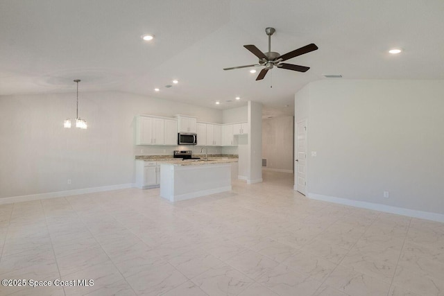 kitchen featuring sink, white cabinetry, appliances with stainless steel finishes, an island with sink, and light stone countertops