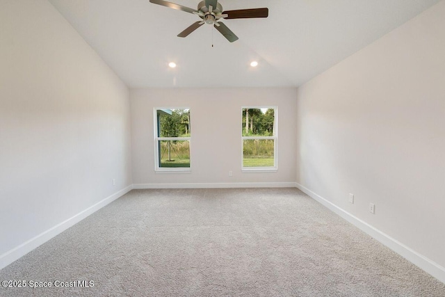 empty room with vaulted ceiling, ceiling fan, and carpet