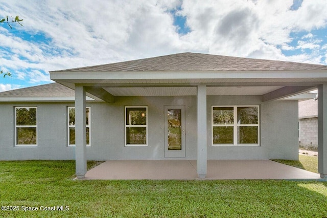 back of property with a yard and a patio