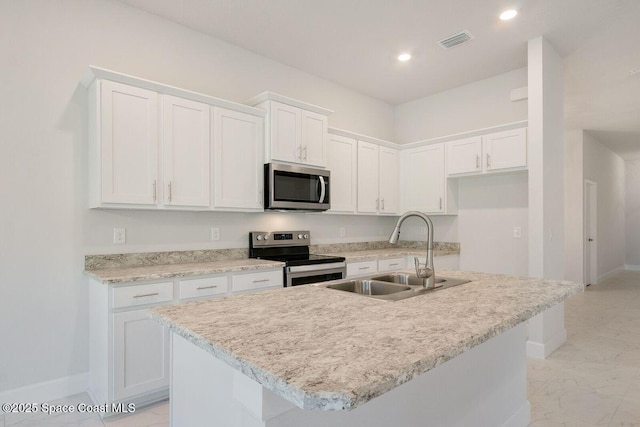 kitchen with white cabinetry, stainless steel appliances, sink, and a kitchen island with sink