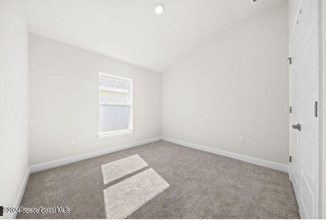 empty room with lofted ceiling and light colored carpet