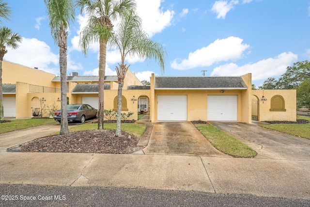 view of front of property featuring driveway, a shingled roof, a garage, and stucco siding