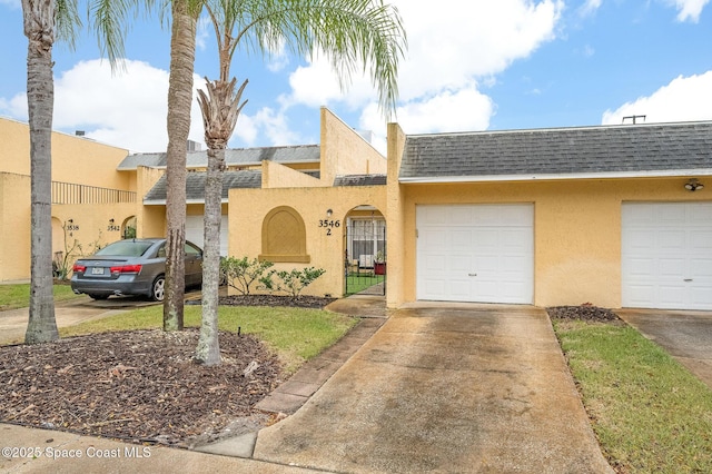 view of front of home featuring a garage, concrete driveway, roof with shingles, and stucco siding