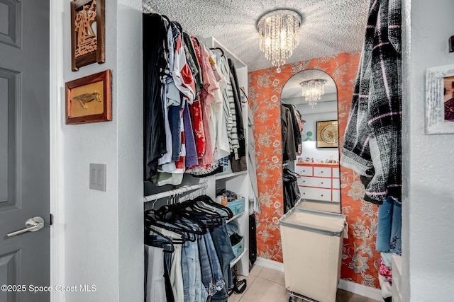 spacious closet featuring a notable chandelier and light tile patterned flooring