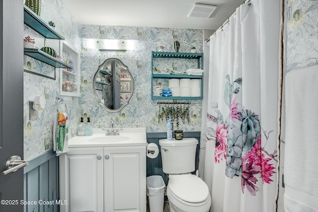 full bath with visible vents, vanity, toilet, and wallpapered walls