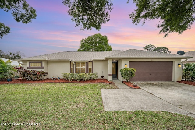 single story home with a garage, stucco siding, concrete driveway, and a yard