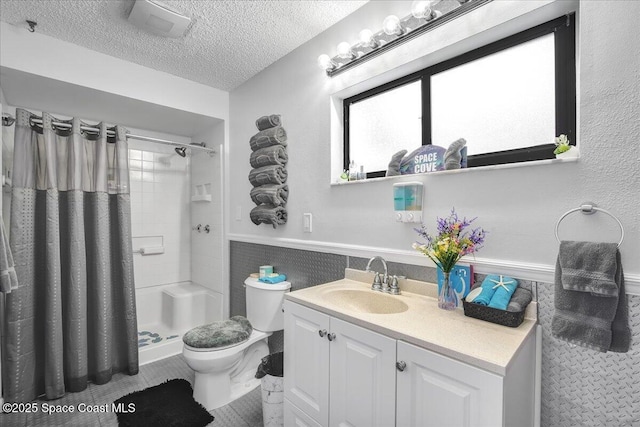 bathroom with vanity, a shower with curtain, toilet, and a textured ceiling