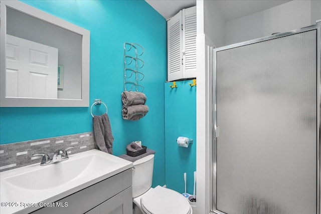 bathroom featuring vanity, toilet, and walk in shower