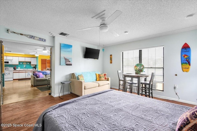 bedroom featuring hardwood / wood-style flooring, ornamental molding, and a textured ceiling