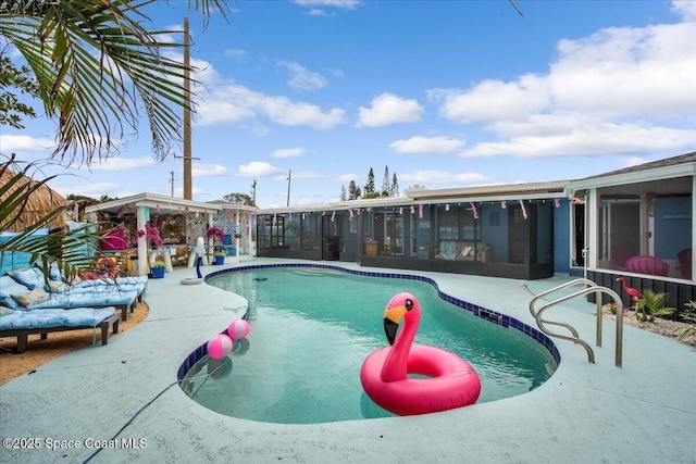 view of swimming pool with a patio area and a sunroom