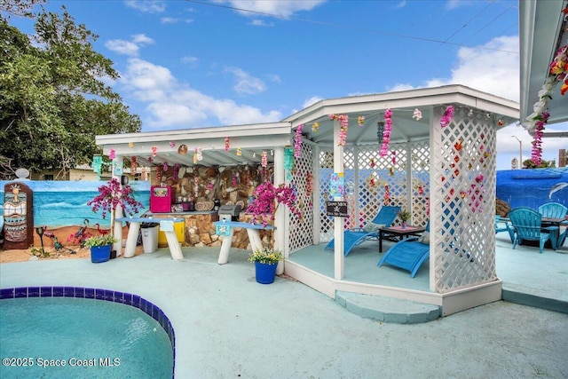 view of swimming pool featuring a gazebo, an outdoor bar, and a patio