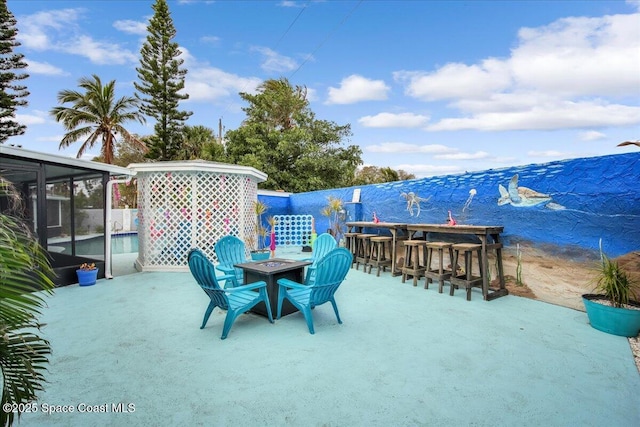 view of patio with a sunroom and a bar