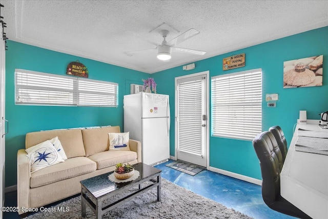 living room featuring ceiling fan, concrete flooring, and a textured ceiling