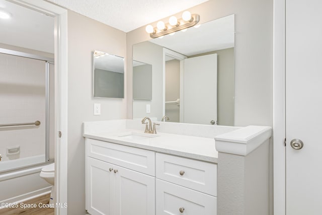 2145 Golf Isle Dr Unit 1212, Melbourne, FL 32935 - full bathroom with toilet, shower / bath combination with glass door, a textured ceiling, vanity, and hardwood / wood-style flooring