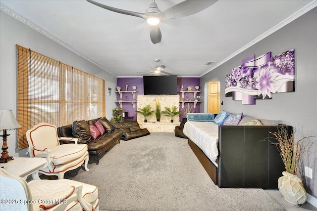 living room featuring ceiling fan, ornamental molding, and carpet