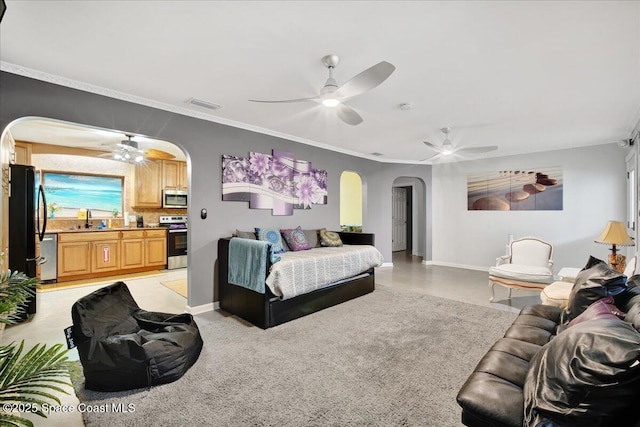 bedroom featuring ornamental molding, black fridge, sink, and ceiling fan