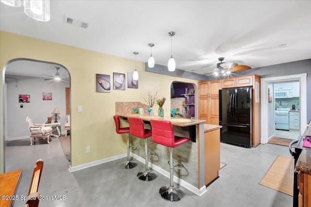 kitchen with white appliances, ceiling fan, hanging light fixtures, a kitchen breakfast bar, and kitchen peninsula