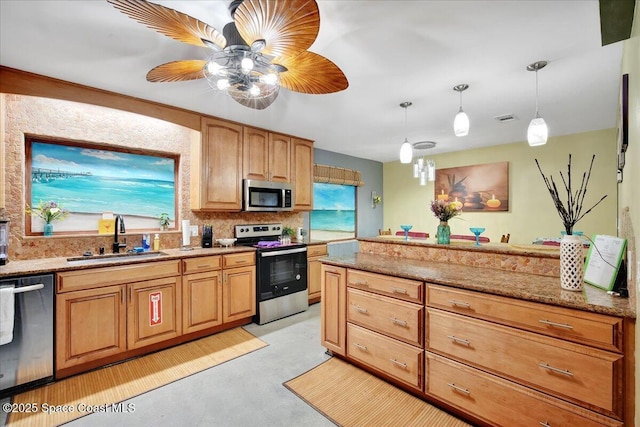 kitchen featuring sink, tasteful backsplash, hanging light fixtures, stainless steel appliances, and light stone countertops