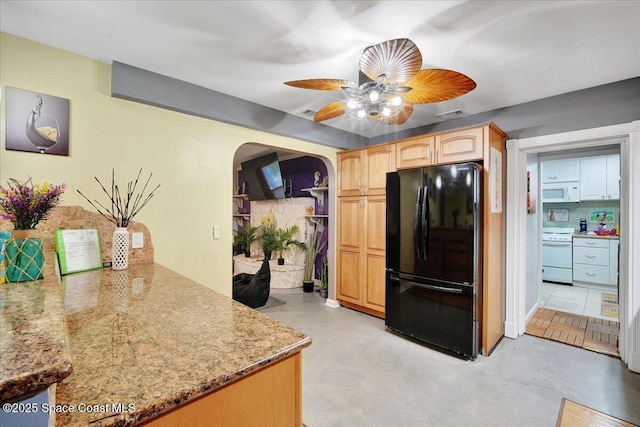 kitchen featuring light brown cabinetry, ceiling fan, white appliances, light stone countertops, and decorative backsplash