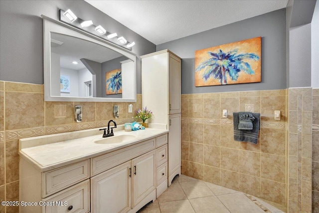 bathroom with vanity, tile walls, tile patterned floors, and a textured ceiling